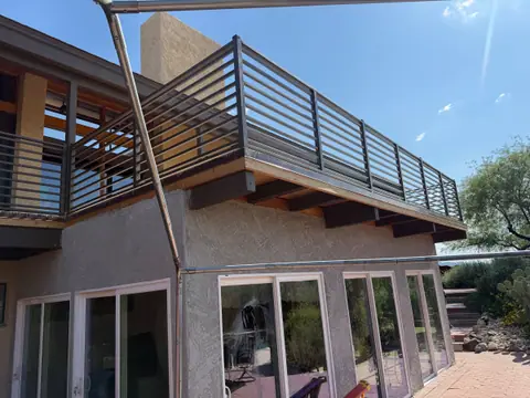 Horizontal bar railing around a second floor balcony deck