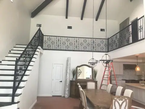 Black steel stair railing and loft balcony railing with scroll panels