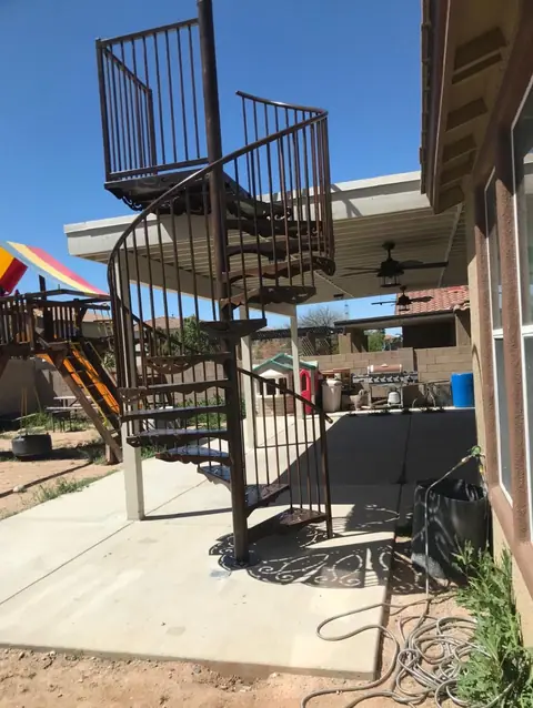 Steel spiral staircase up to a rooftop deck