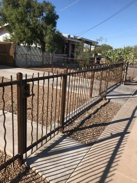 Steel picket fence with a walk gate along a sidewalk
