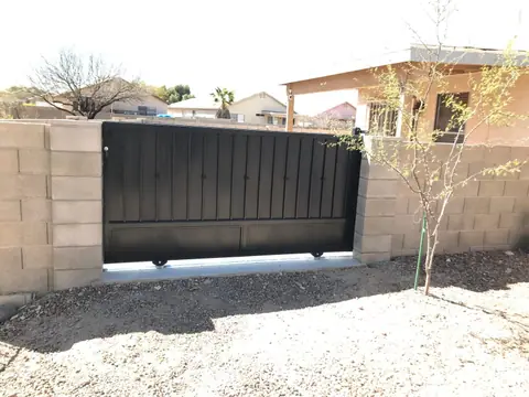 Black solid rolling gate in a block wall opening