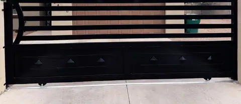 Black rolling gate with horizontal slats and a diamond panel base